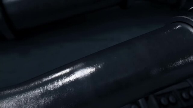 Black leather wrist cuff with metal studs resting on a dark surface in moody light