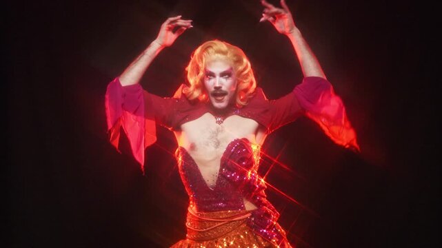 Charismatic drag queen dancing in a red sequin outfit