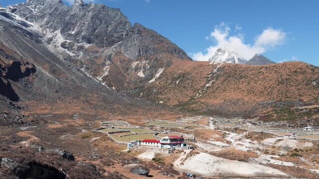 Beautiful himalayan mountain landscape with the small village of dingboche nestled in a high altitude valley, showing path of everest base camp trek under a clear blue sky in nepal