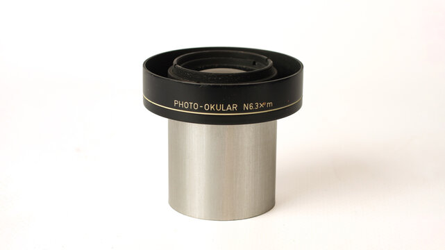 Microscope photo eyepiece marked 6.3x, with a black upper housing, silver metal barrel and threaded optical opening, isolated on a white background.