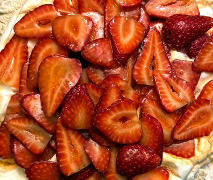 Sweet juicy honey glazed strawberries on a Pavlova dessert