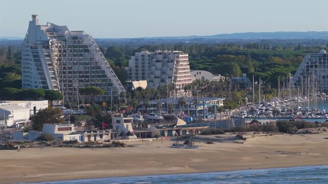 Aerial parallax view of Petite Motte beachfront apartments in La Grande-Motte with Pic Saint-Loup and Montpellier in background, France