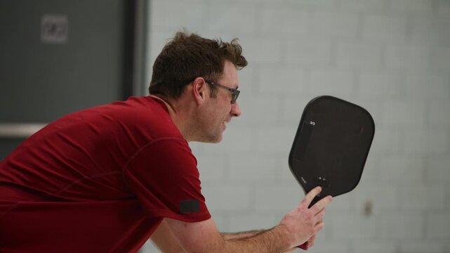 Co ed pickleball players in a modern gymnasium