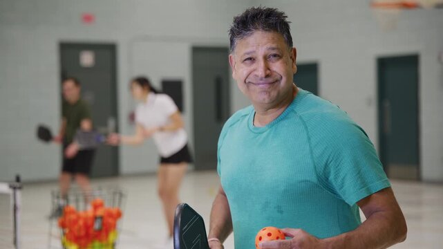 Co ed pickleball players in a modern gymnasium