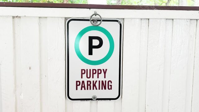 Puppy Parking Informational Sign Mounted on White Wooden Fence