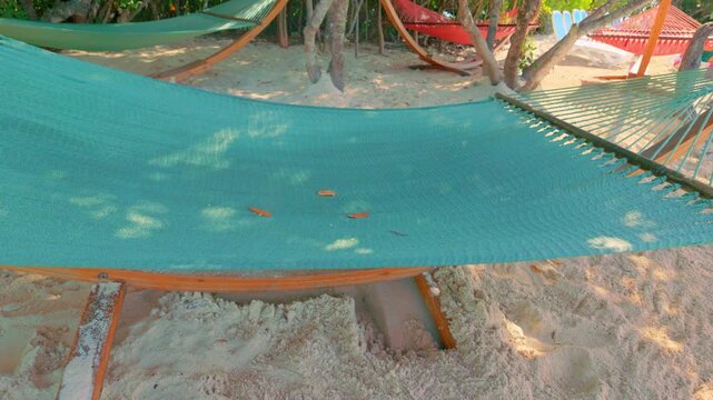 Empty Green Rope Hammocks and Wooden Stands on Tropical Sand Beach