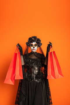 Young woman celebrates Dia de los Muertos with elegance and style while holding shopping bags on black friday 