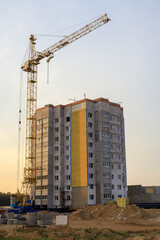 Tall yellow tower crane working at modern residential building construction site. High rise development, urban expansion, and building machinery © yaviki