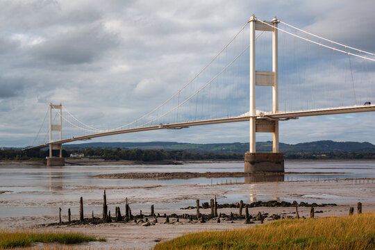 Severn Bridge suspension bridge and weathered wooden jetty remains on Aust shore