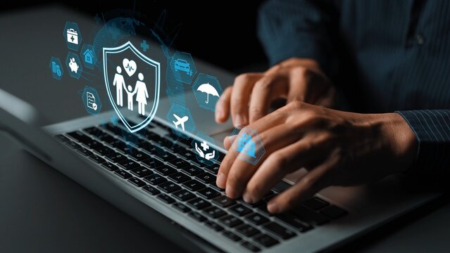 Person typing on laptop with health insurance icons and symbols floating above, representing digital solutions for insurance and finance sectors. Entropy.