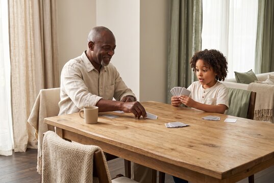 Grandfather and grandson enjoying playing cards together at home