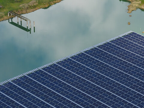 Aerial view of floating solar panels on a calm lake surface near the shore of Ragakapa Nature Park in Jurmala, Latvia.