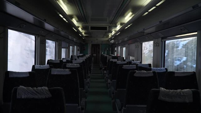 Empty train cabin glows dimly under overhead lights