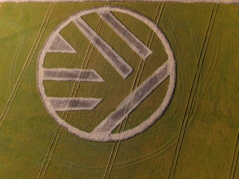 Aerial view of a large Volkswagen logo created in a green field with crop lines visible in Caledon, Western Cape, South Africa.