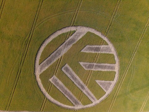 Aerial view of a large Volkswagen logo crop circle carved into a green agricultural field in Caledon, Western Cape, South Africa.