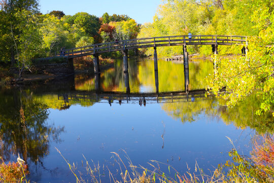 Historic Old North Bridge in Concord, Massachusetts Surrounded by Autumn Foliage and Calm River Reflections