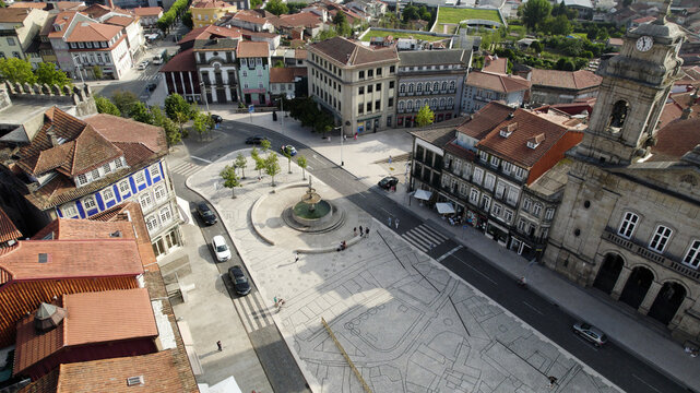 Aerial view of the historic town square with a central fountain, surrounding traditional buildings with terracotta roofs, and cobblestone streets in Guimaraes, Braga, Portugal.