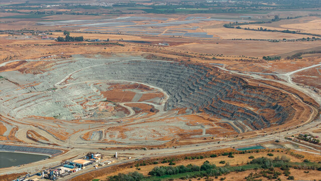Aerial view of the Mina Cobre Las Cruces open-pit copper mine with terraced walls and industrial facilities in the arid landscape of Gerena, Andalucia, Spain.