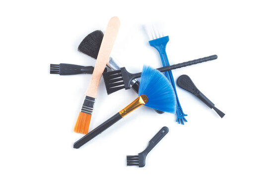 Various cleaning brushes and dusting tools for electronics maintenance isolated on white background. Camera sensor cleaning, keyboard duster, optic care equipment and precision tool set concept.