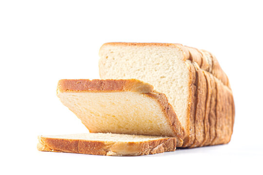 Sliced white toast loaf with falling slice isolated on white background. Sliced bread, bakery product, grocery staple, sandwich preparation, carbohydrate source and morning breakfast food concept.