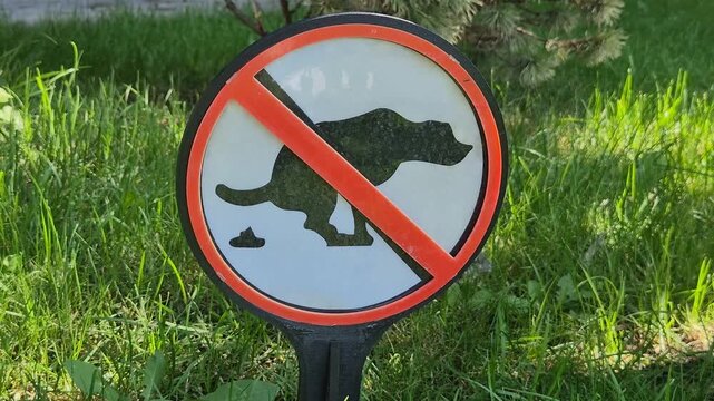 Warning notice forbidding dog walking and fouling on grass background