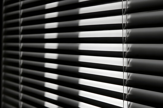Closed horizontal window blinds in black and white create repeating lines, soft gradients, and shadow patterns for a minimalist interior, privacy concept, architectural detail, or abstract background