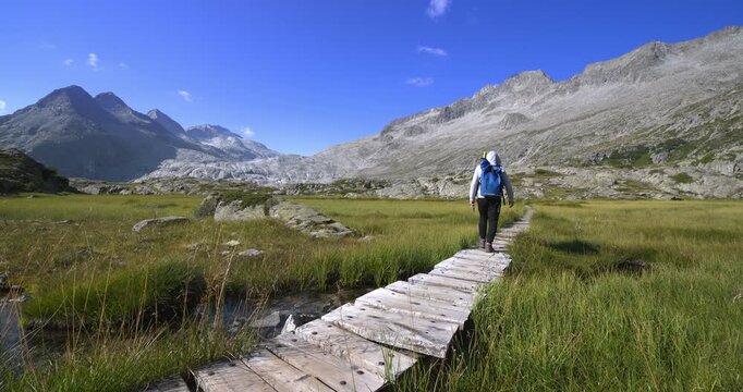A young man walks along a walkway in the Mandrone Dolomites