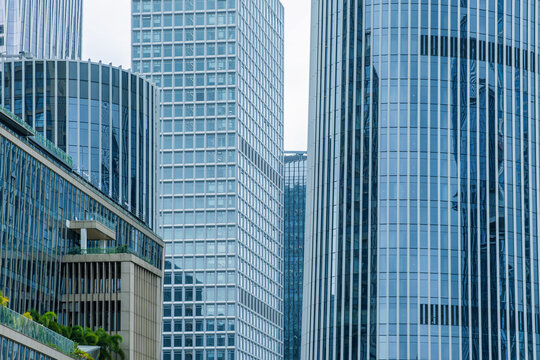 Close up of modern glass skyscraper facades with windows, vertical lines and geometric forms in Shenzhen, China. Abstract architecture background, reflective glass texture, facade pattern