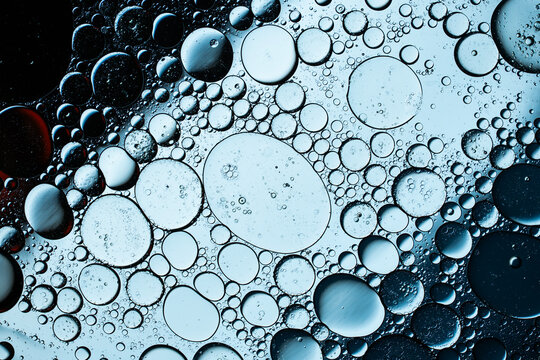 Macro view of blue oil droplets floating on water surface
