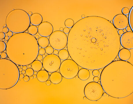 Close up of oil droplets floating in water with golden light