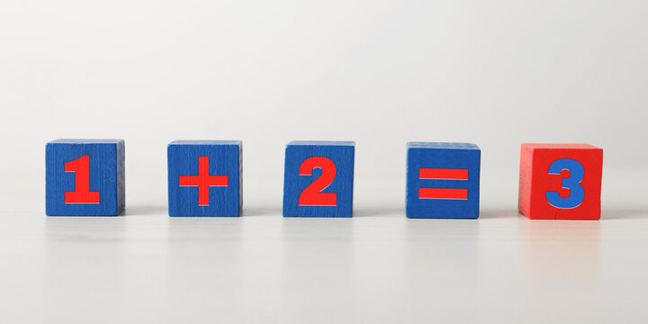 Mathematical equation made with colorful cubes on table. Banner design