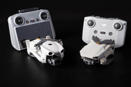 DJI Mini 2 and Lito X1 drones with their controllers; close-up of the DJI Mini 2 and Lito X1 drones  with their respective RC-N1 and RC 2 controllers against a black background, selective focus.