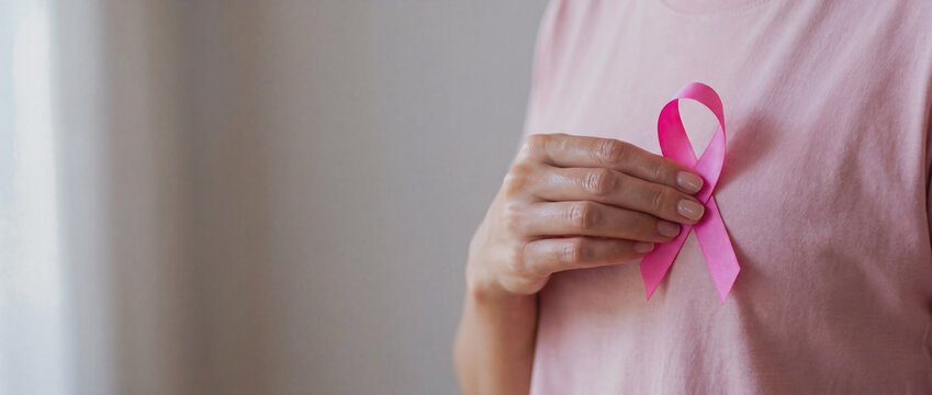 Woman Holding Pink Ribbon on Chest Symbolizing Breast Cancer Awareness and Health Campaign for Medical Support and Research