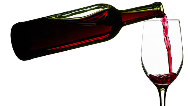 Isolated elegant red wine pouring from a bottle into a crystal glass with splash.