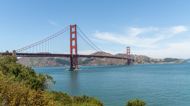 Golden Gate Bridge, San Francisco, California, USA, the red suspension bridge crossing the Golden Gate strait toward the Marin Headlands, framed by coastal shrubs