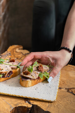 Preparing a snack with fresh toppings on bread at a casual setting