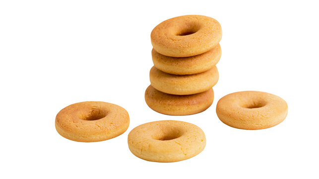 Isolated stack of plain sweet golden ring-shaped baked cookies and individual biscuits