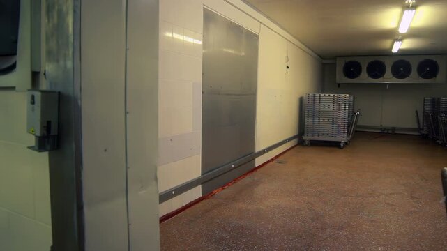 Cold storage door opening dairy plant. Handheld reveal empty refrigeration room