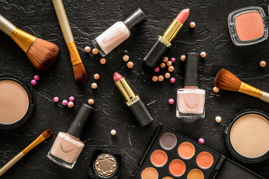 Beige and nude tones cosmetics for natural makeup on black background top view