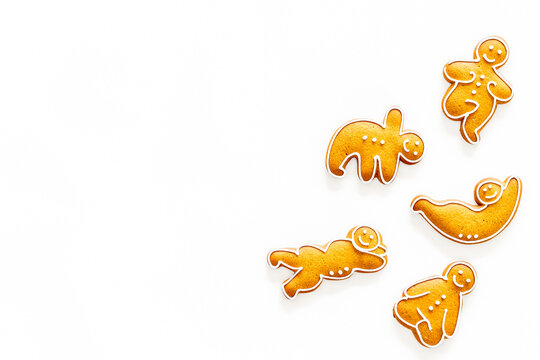 Gingerbread cookies in shape of yoga asanas on white background top view copyspace
