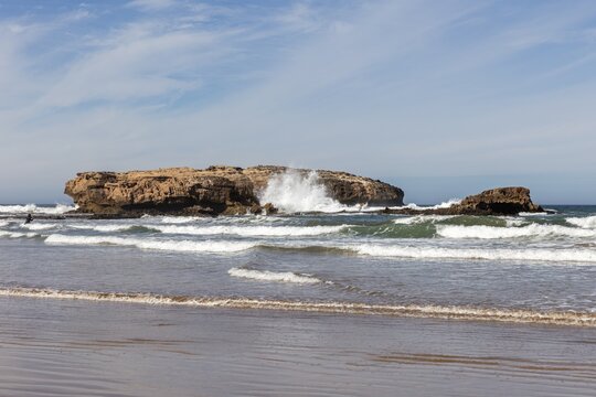 Rocky coast with breaking waves under clear sky