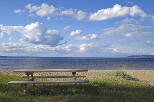 Empty picnic bench overlooking the sea under a partly cloudy sky, Lake V&auml;ttern, J&ouml;nk&ouml;pings l&auml;n, J&ouml;nk&ouml;ping, Sweden