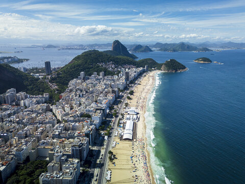 Aerial view of Copacabana Beach with its iconic mosaic promenade, dense urban buildings, and the Atlantic Ocean in Rio de Janeiro, Rio de Janeiro, Brazil.