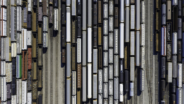 Aerial view of CSX's Radnor Yard and Nashville Intermodal train terminal with rows of freight train cars and cargo containers on parallel tracks in Nashville, TN, United States.