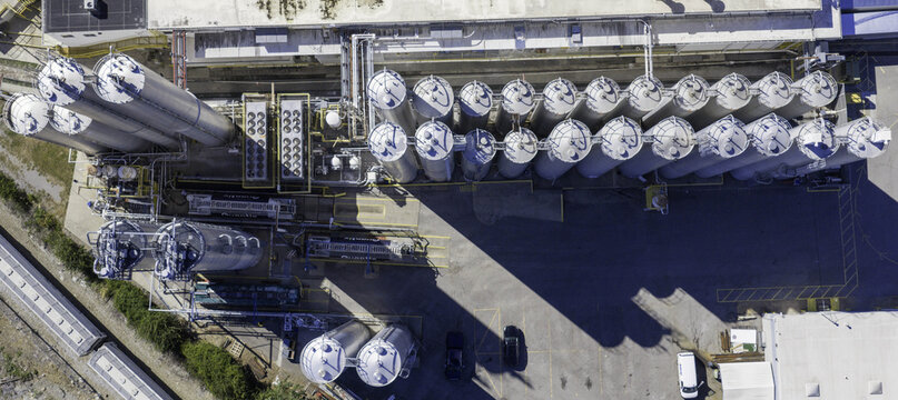 Aerial view of industrial storage silos and tanks arranged in rows at a facility, with pipes, cooling units, and vehicles in the paved yard in Nashville, TN, United States.