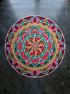 Traditional colorful rangoli mandala on stone floor