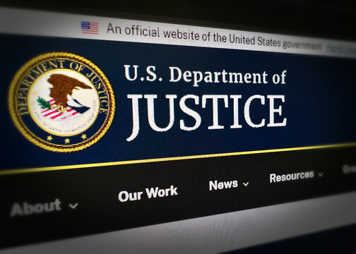 Close up of the U.S. Department of Justice official website homepage on a computer screen with navigation menu, illustrative editorial 