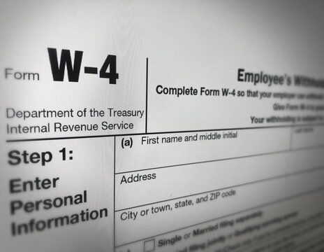 Close up of US form W-4 showing personal information section with text fields and instructions on white background, sample