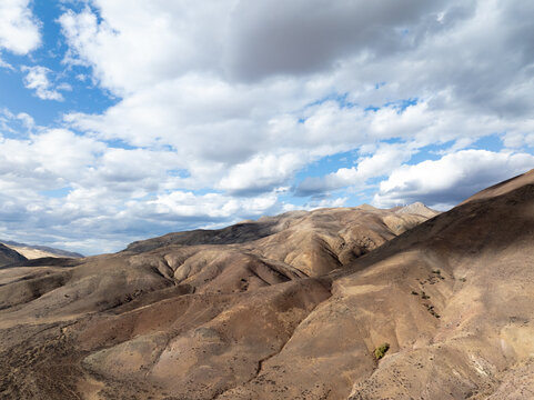 Sunlit mountain ridges stretch under dynamic clouds