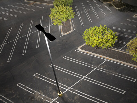 Aerial photo of deserted parking area with white lines and greenery